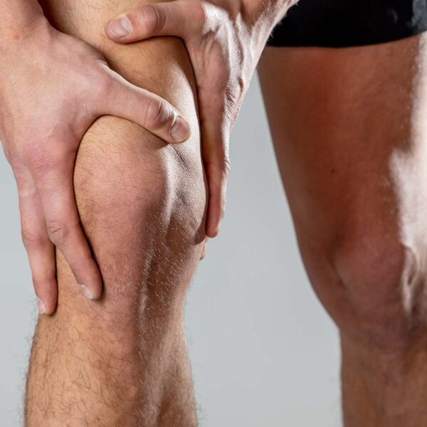 image of legs showing a man holding his knee with both hands