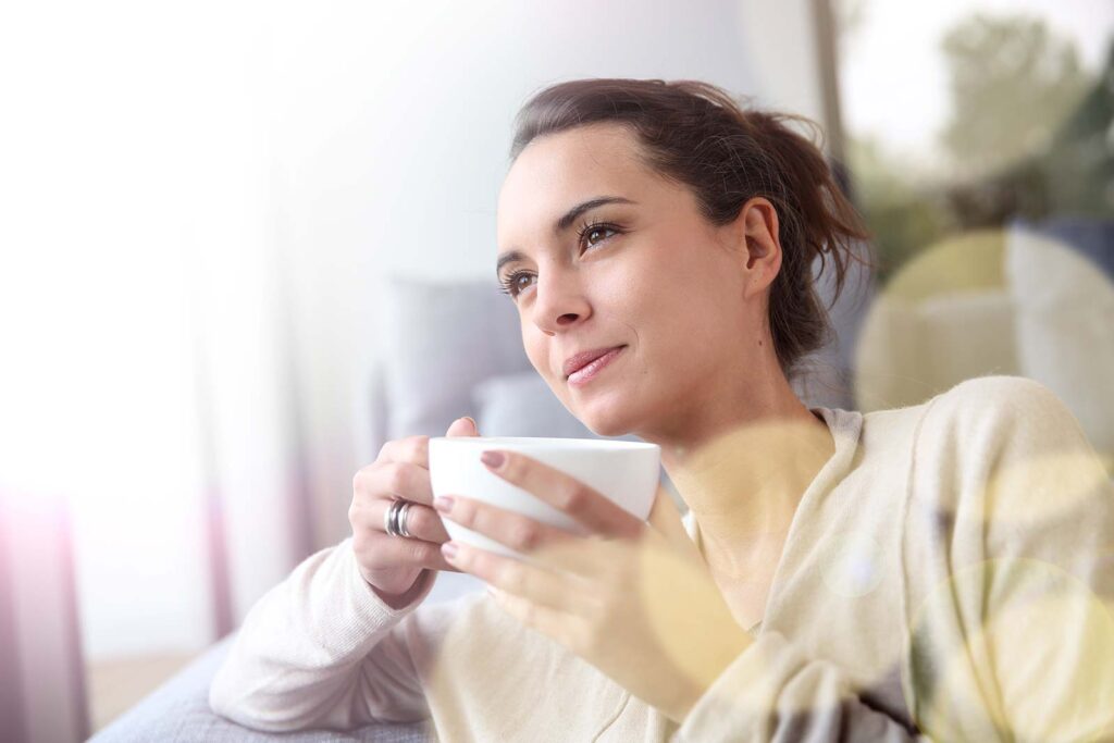 lady looking very engaged holding a white cup of coffee