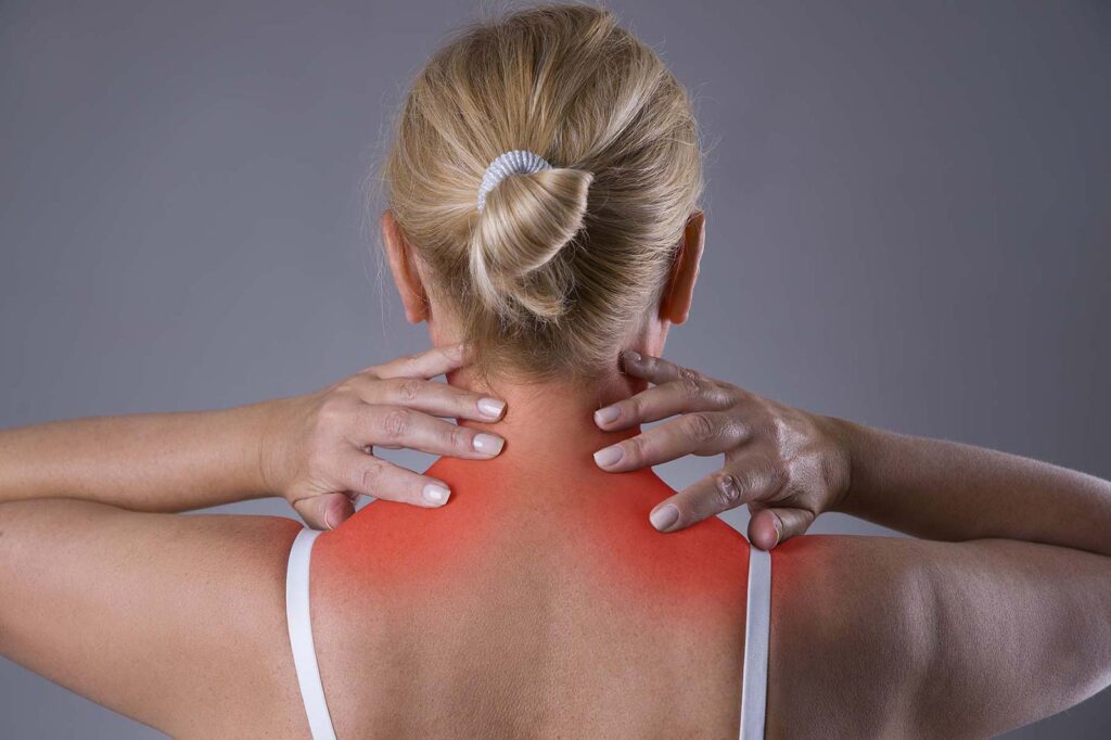 rear view of lady holding her lower neck area with both hands. the collar area is highlighted in red.